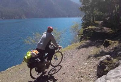 person biking along water's edge