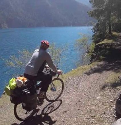 person biking along water's edge